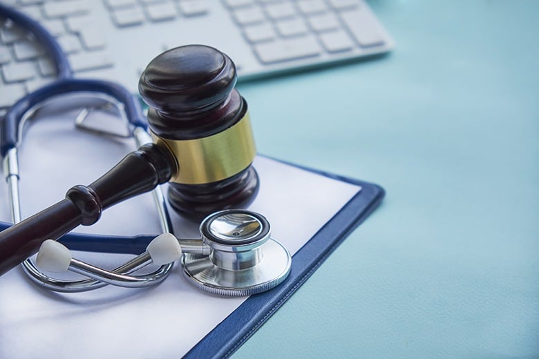 gavel and stethoscope next to keyboard