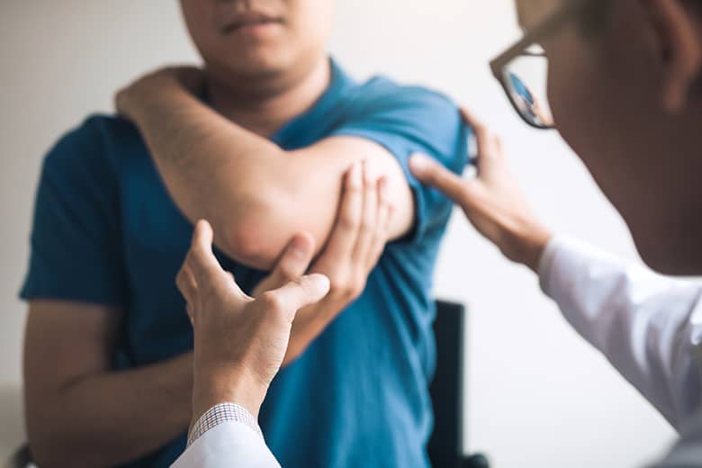 doctor examining patients elbow