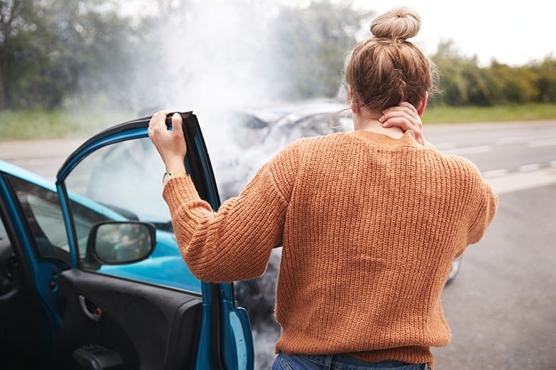 girl holding neck after car accident