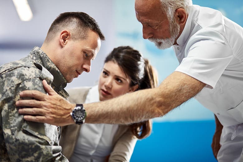 two people comforting solider