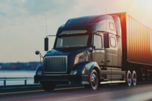 black-truck-driving-down-highway-at-sunset